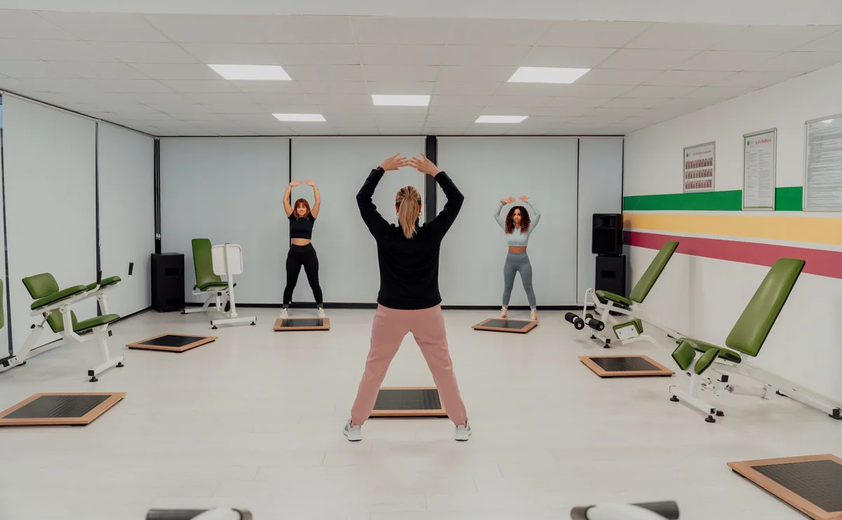 Eğitmen eşliğinde mat üzerinde pilates dersi
